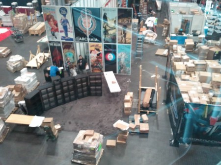 The Archaia/Boom booth, at Noon Wednesday. To the right, the "storeroom" for a videogame company takes up half of their booth.