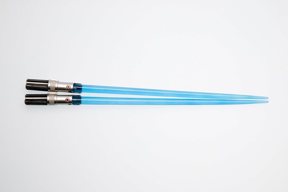A pair of glowing blue lightsaber chopsticks against a white background