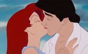 The kiss between Ariel (white redheaded woman) and Eric (white man with brown hair) from Disney's 1989 animated The Little Mermaid movie.