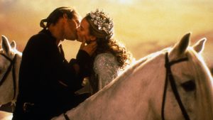 Wesley (white blond man) and Princess Buttercup (white blonde woman, crowned) share a kiss on horseback from The Princess Bride (1987)