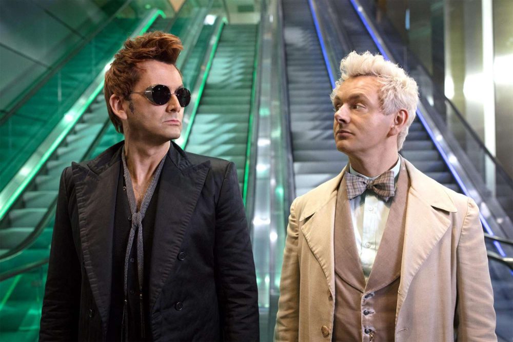 David Tennant as the demon Crowley and Michael Sheen as the angel Aziraphale look at each other in front of the elevators that will take them to their respective afterlife desinations.