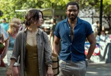 TV Review: MR. & MRS. SMITH hits its target in a fun reinterpretation Maya Erskine, an Asian woman dressed in a brown and grey, and Donald Glover, a Black man with short hair wearing a blue shirt, as Mr. & Mrs. Smith