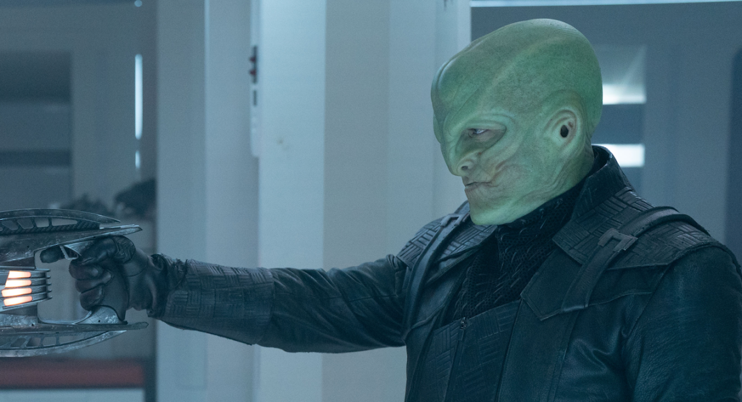 L'ak (Elias Toufexis) holds a weapon on the ISS Enterprise in Star Trek: Discovery season 5 episode 5, "Mirrors."