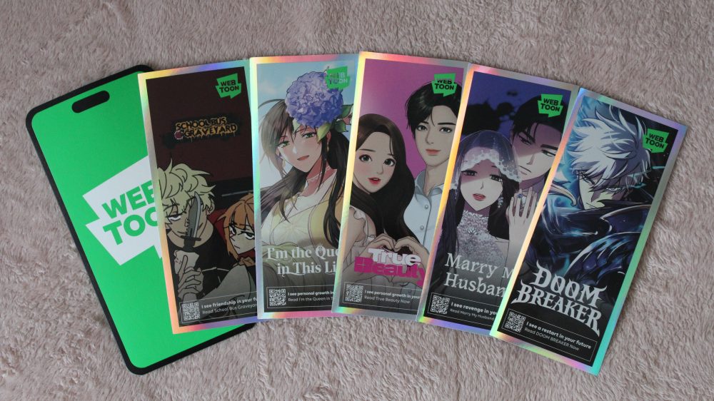 an assortment of phone-sized stickers from a WEBTOON sleeve given out in the event.