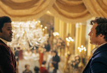 TV Review: DOCTOR WHO’s ‘Rogue’ steals more hearts than just the Doctor’s The Doctor (portrayed by Ncuti Gatwa, a black man with his hair tied back, wearing a plum waistcoat and white trousers,) speaks with the mysterious brooding stranger on the balcony (portrayed by Jonathan Groff, a white man with short brown hair wearing a blue waistcoat.)