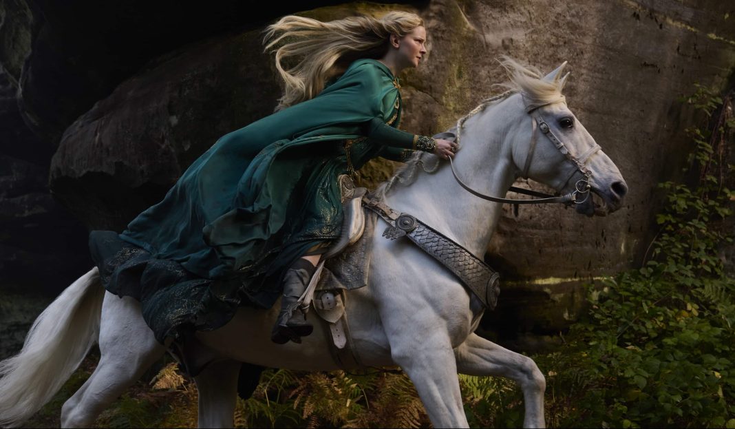 Morfydd Clark as Galadriel riding on white horse in green dress in The Rings of Power