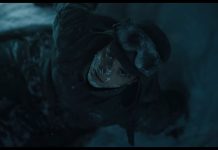 MICKEY 17 is a comic book movie in the best way mickey 17 header. shot from above of man wearing snow gear and staring up at camera
