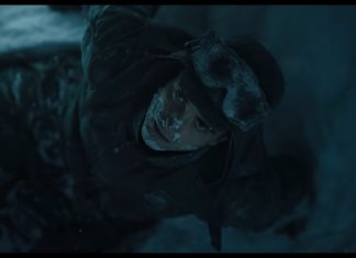MICKEY 17 is a comic book movie in the best way mickey 17 header. shot from above of man wearing snow gear and staring up at camera