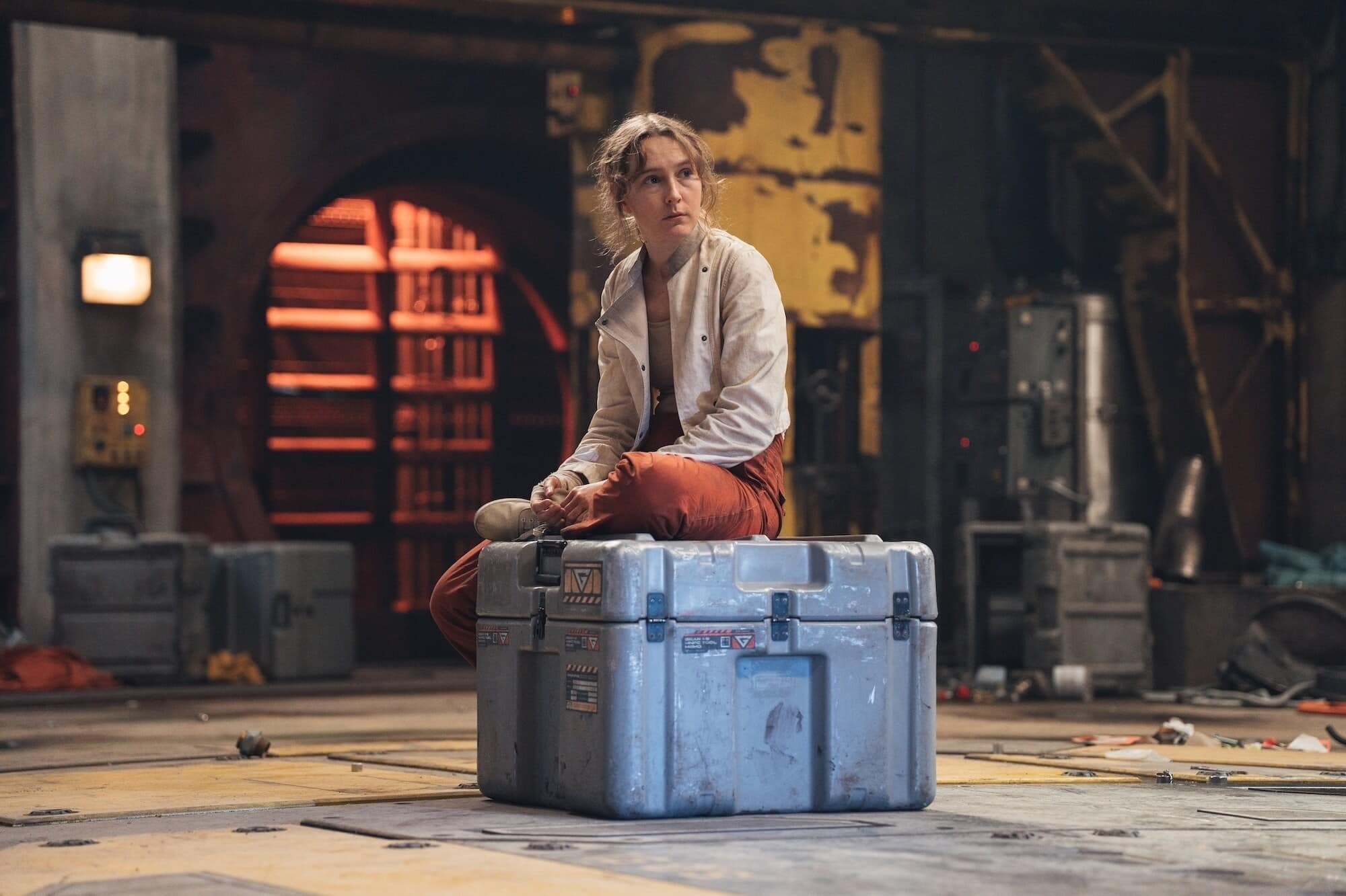 Aliss sits on a chest awaiting her fate.