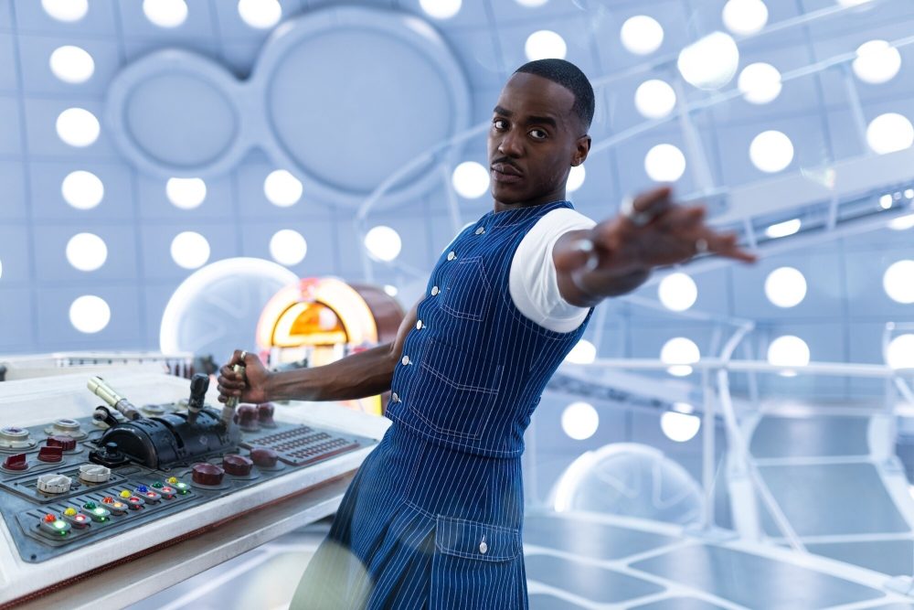The Doctor (Ncuti Gatwa) reaching out his hand while operating his TARDIS
