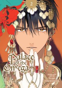 A tan man with black hair with gold jewelry stares intensely at the audience