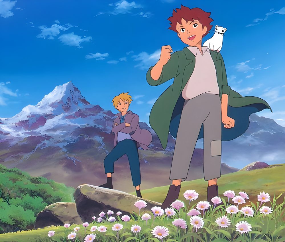 Two boys run through the fields with the mountains behind them.