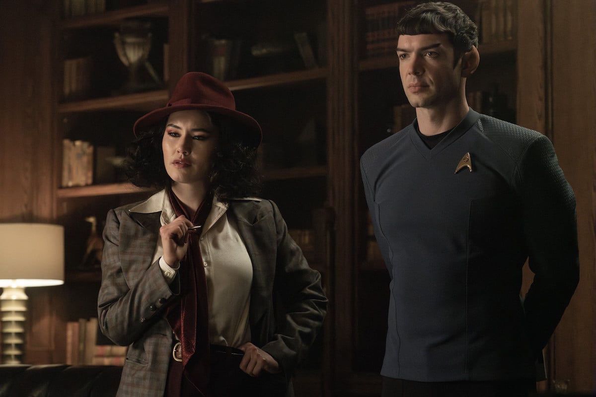 La'an in incongruous historical clothing beside Spock in uniform. They're both in some kind of library.