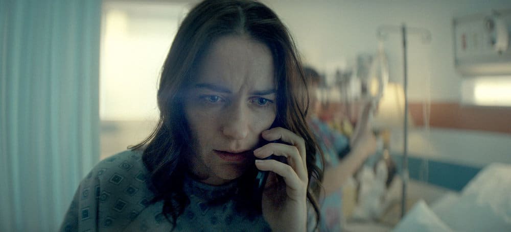Melanie Scorfano as Dana Cyprus phone to her left ear.