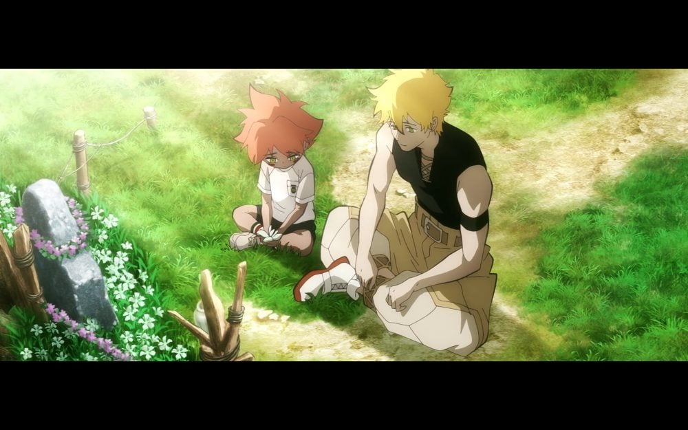 little johnny and his father sit together by a gravestone wrapped in flowers.