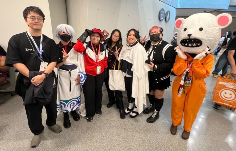 yu saito with cosplayers dressed as characters from gintama, world trigger, and other series he supervised