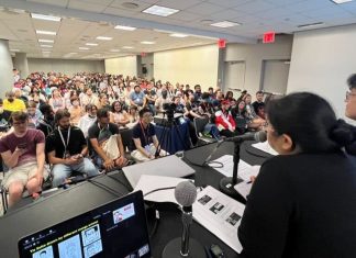 AnimeNYC 2025: Behind WEEKLY SHONEN JUMP, a conversation with the editor-in-chief photo of panel room showing packed crowd as well as panel moderator and yu saito.