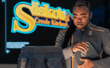 The Beat’s STAR TREK: STARFLEET ACADEMY “Series Acclimation Mil” spoiler roundtable SAM standing in front of a sign for Sisko's Creole Kitchen on Star Trek: Starfleet Academy.