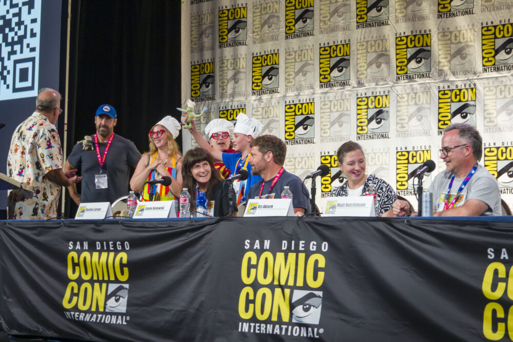 The Tiny Chef Show Rides Again Panel with Moderator Gary Miereanu, Rachel Larsen, Jason Kolowski, Ozi Akturk, and Matt Hutchinson alongside fans at the end of the panel.