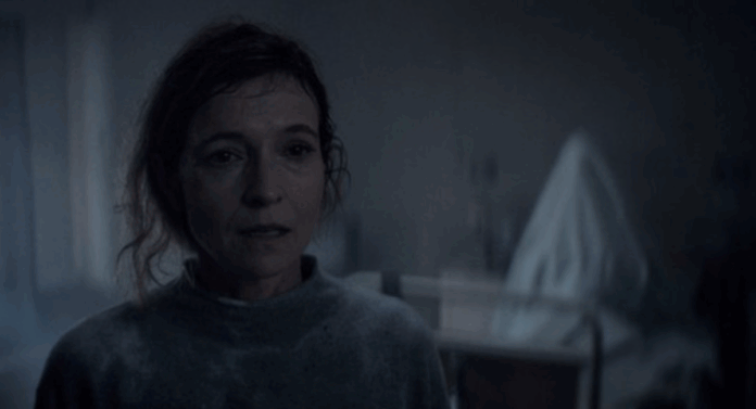 Screenshot 2026-07-14 at 6.21.51 PM A ghostly figure rises behind Tandi Wright's Susan in Evil Dead Burn