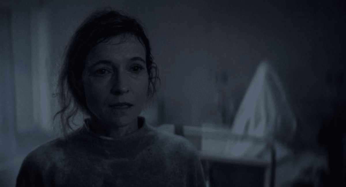 Screenshot 2026-07-14 at 6.21.51 PM A ghostly figure rises behind Tandi Wright's Susan in Evil Dead Burn