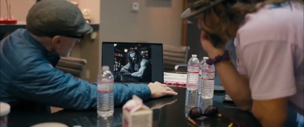 Craig Gillespie and Jason Momoa discussing a Lobo design on a laptop