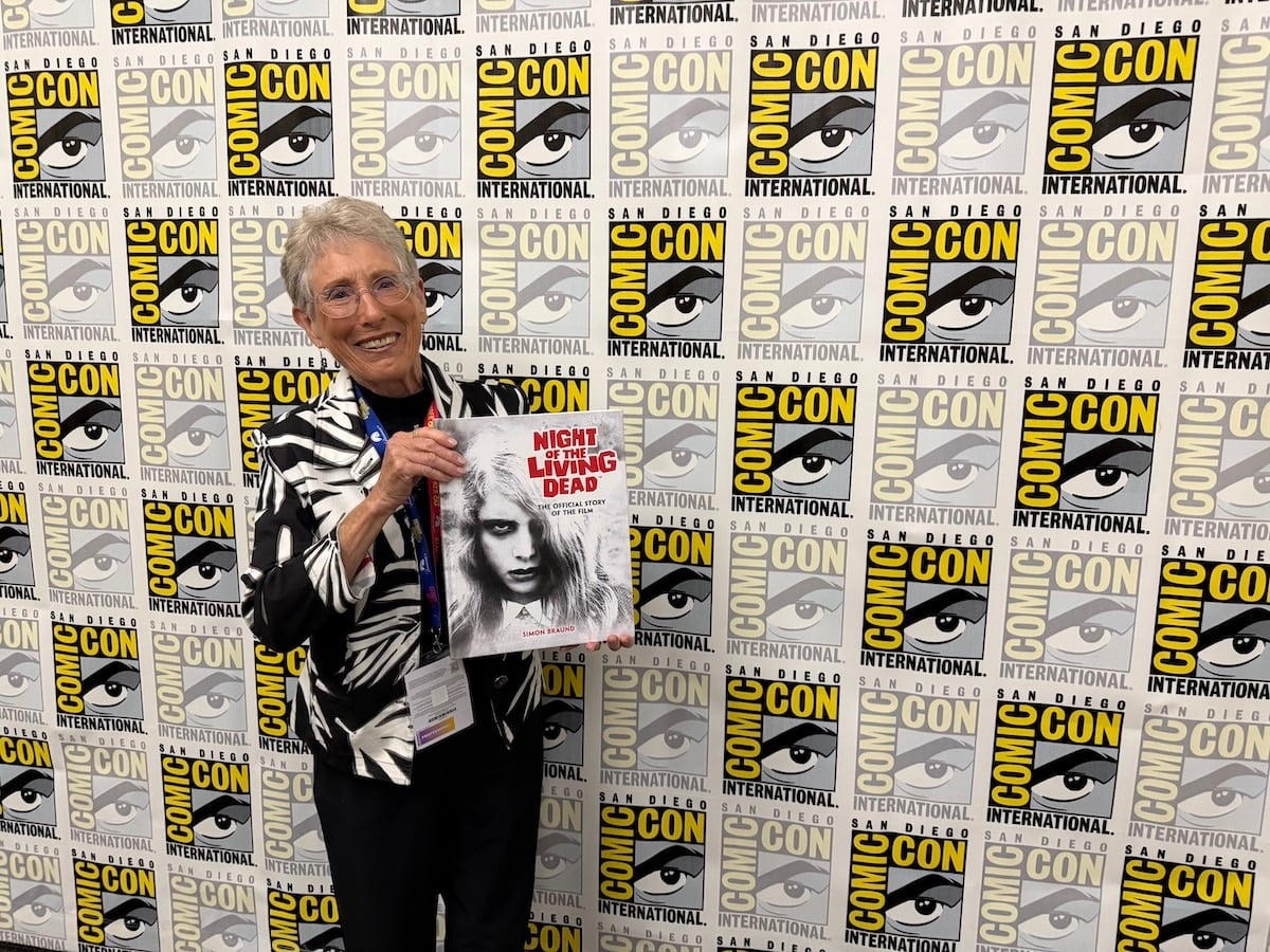 Judith O'Dea at San Diego Comic-Con on Thursday, July 23rd, 2026, holding a copy of Night of the Living Dead: The Official Story of the Film. Credit: Avery Kaplan.