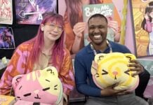 NYCC ‘26: Kim-Joy discusses QUIET graphic novel and bringing baking and mental health into graphic novels The Beat reporter Aaron Halls and Kim-Joy seated at artist alley at NYCC '26 to discuss Quiet smiling and holding plushies.