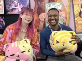 NYCC ‘26: Kim-Joy discusses QUIET graphic novel and bringing baking and mental health into graphic novels The Beat reporter Aaron Halls and Kim-Joy seated at artist alley at NYCC '26 to discuss Quiet smiling and holding plushies.