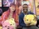 NYCC ‘26: Kim-Joy discusses QUIET graphic novel and bringing baking and mental health into graphic novels The Beat reporter Aaron Halls and Kim-Joy seated at artist alley at NYCC '26 to discuss Quiet smiling and holding plushies.